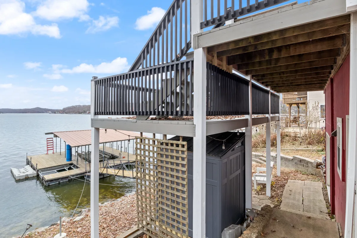 A peaceful dock scene showing a well-maintained dock stretching out over the water, with a staircase leading down from the deck and clear views of the waterfront. The setting exudes calmness, inviting guests to relax, fish, or launch into the lake.